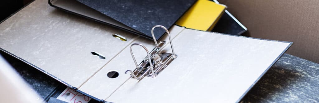 Foto für den Blogartikel "In die Privatinsolvenz ohne Unterlagen - ist das möglich?". Auf dem Foto sieht man leere, durcheinanderliegende Aktenordner, die fehlende Dokumente bei der Anmeldung zur Privatinsolvenz symbolisieren sollen.