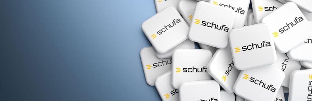 Foto für den Blogartikel "Neues Bewertungssystem der Schufa - was ändert sich?". Auf dem Foto sieht man viele übereinanderliegende Karten mit Schufa-Aufdruck vor blauem Hintergrund.